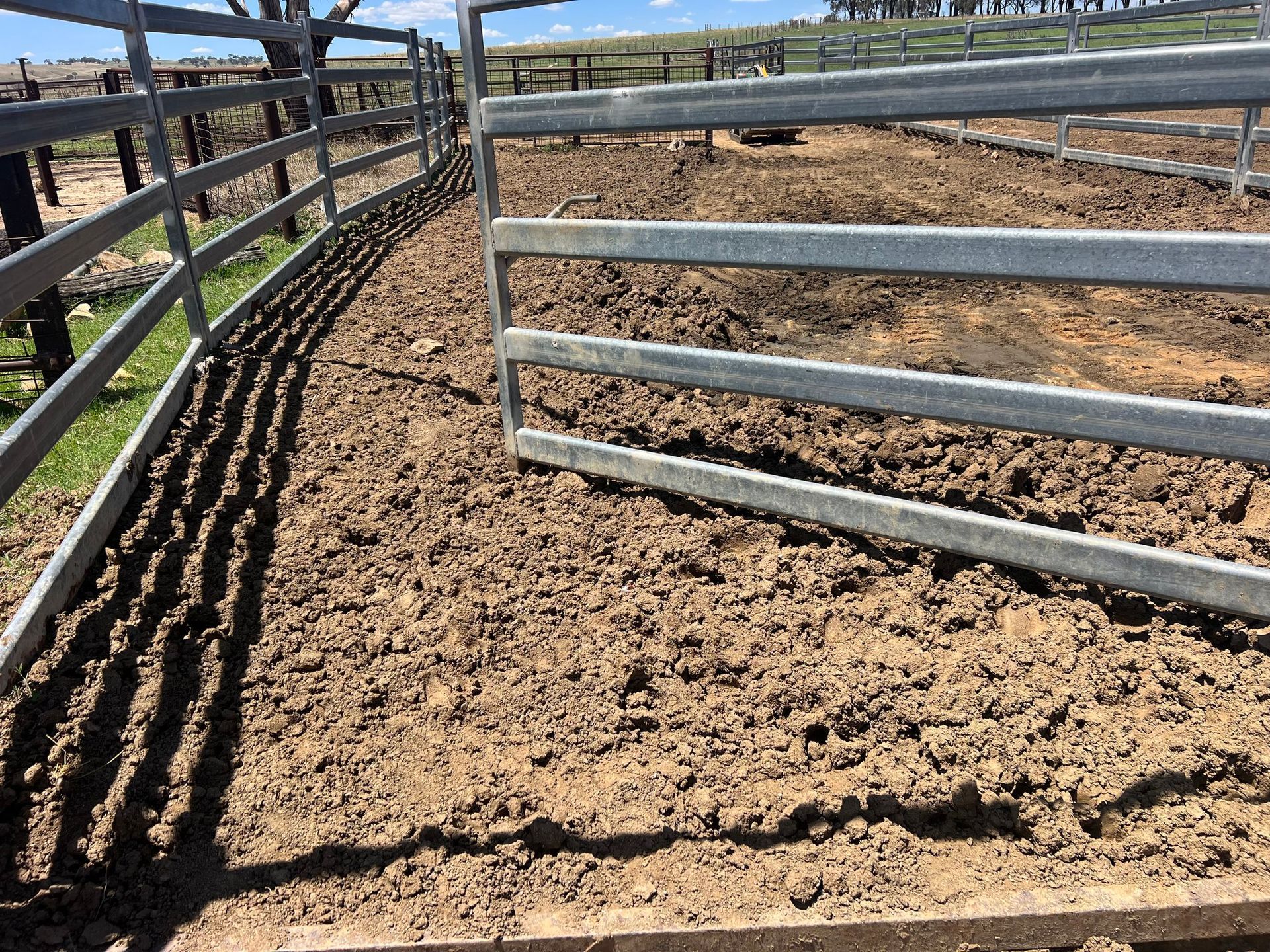 A muddy field with a fence in the background.