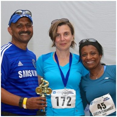 A man wearing a samsung shirt poses with two women