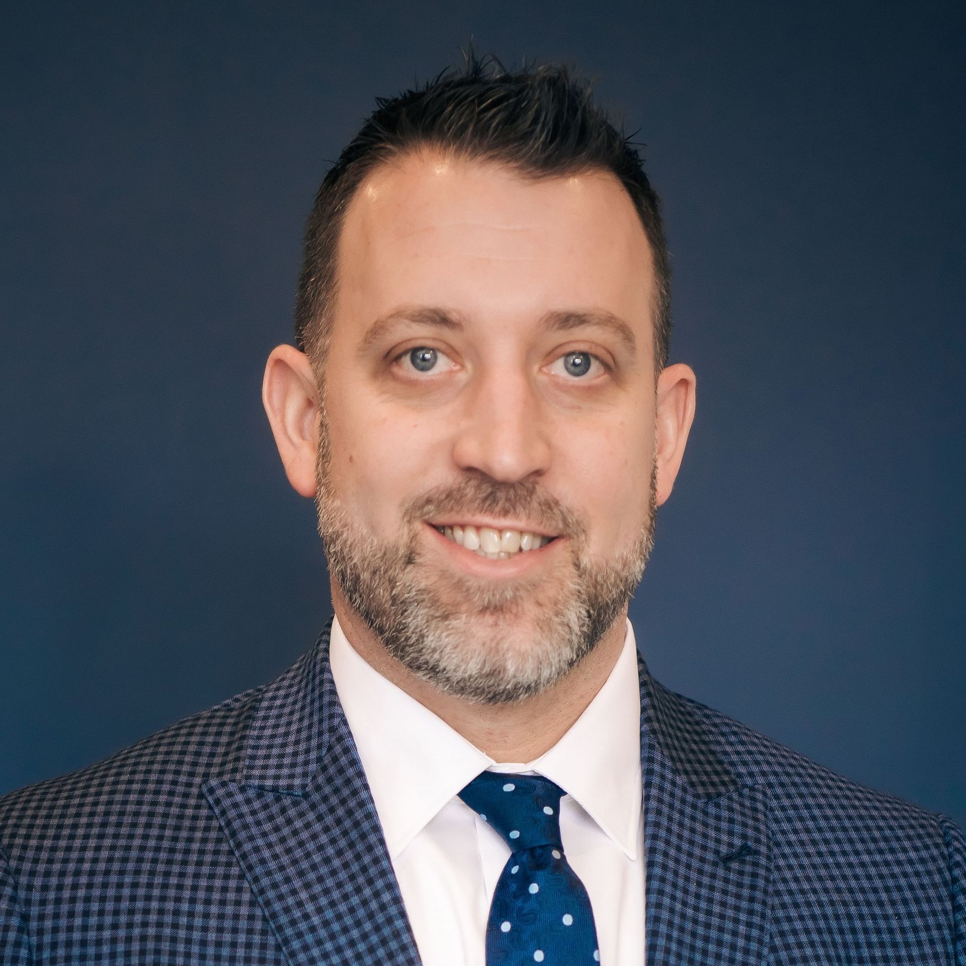 A man in a suit and tie is smiling for the camera.