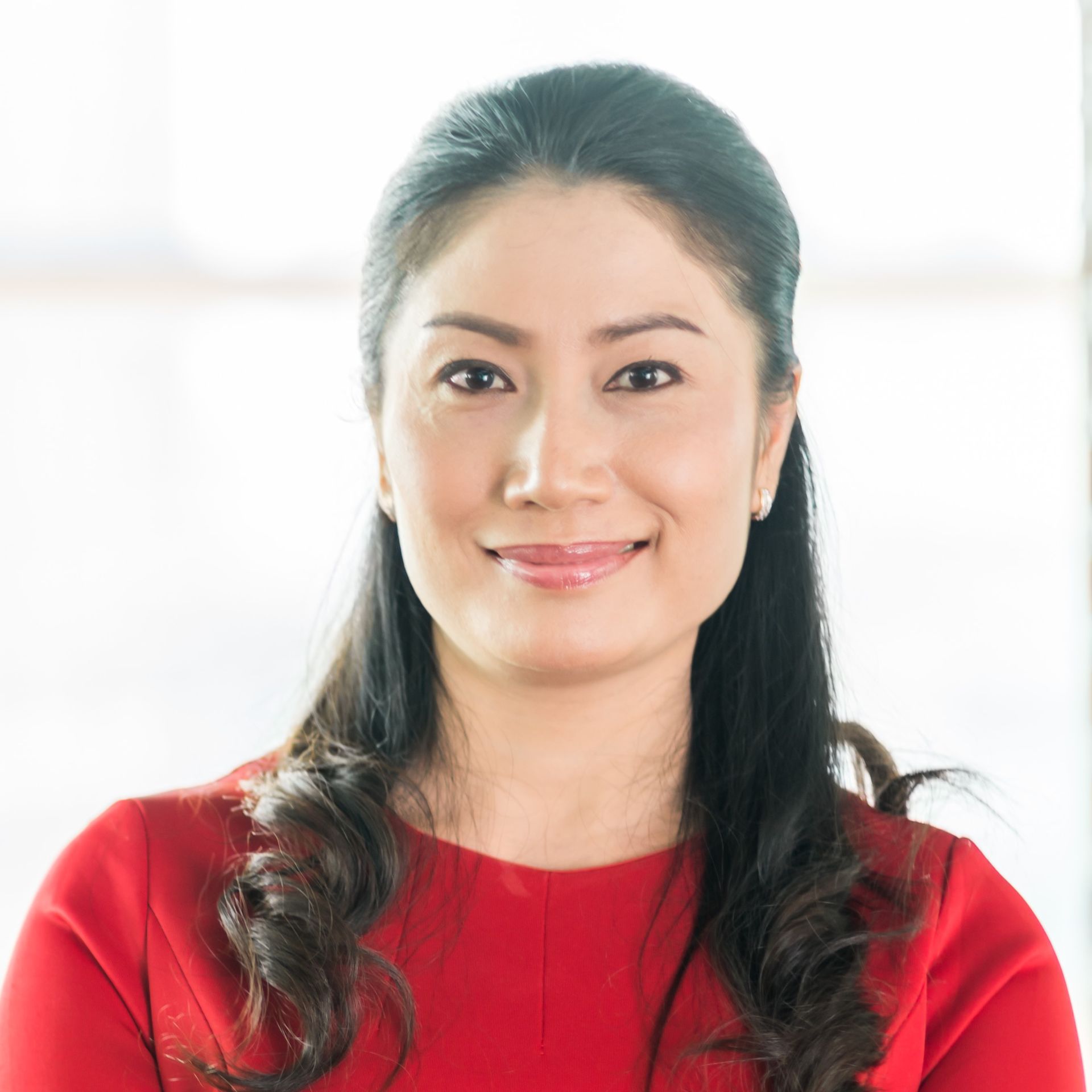 A woman in a red dress is smiling for the camera.
