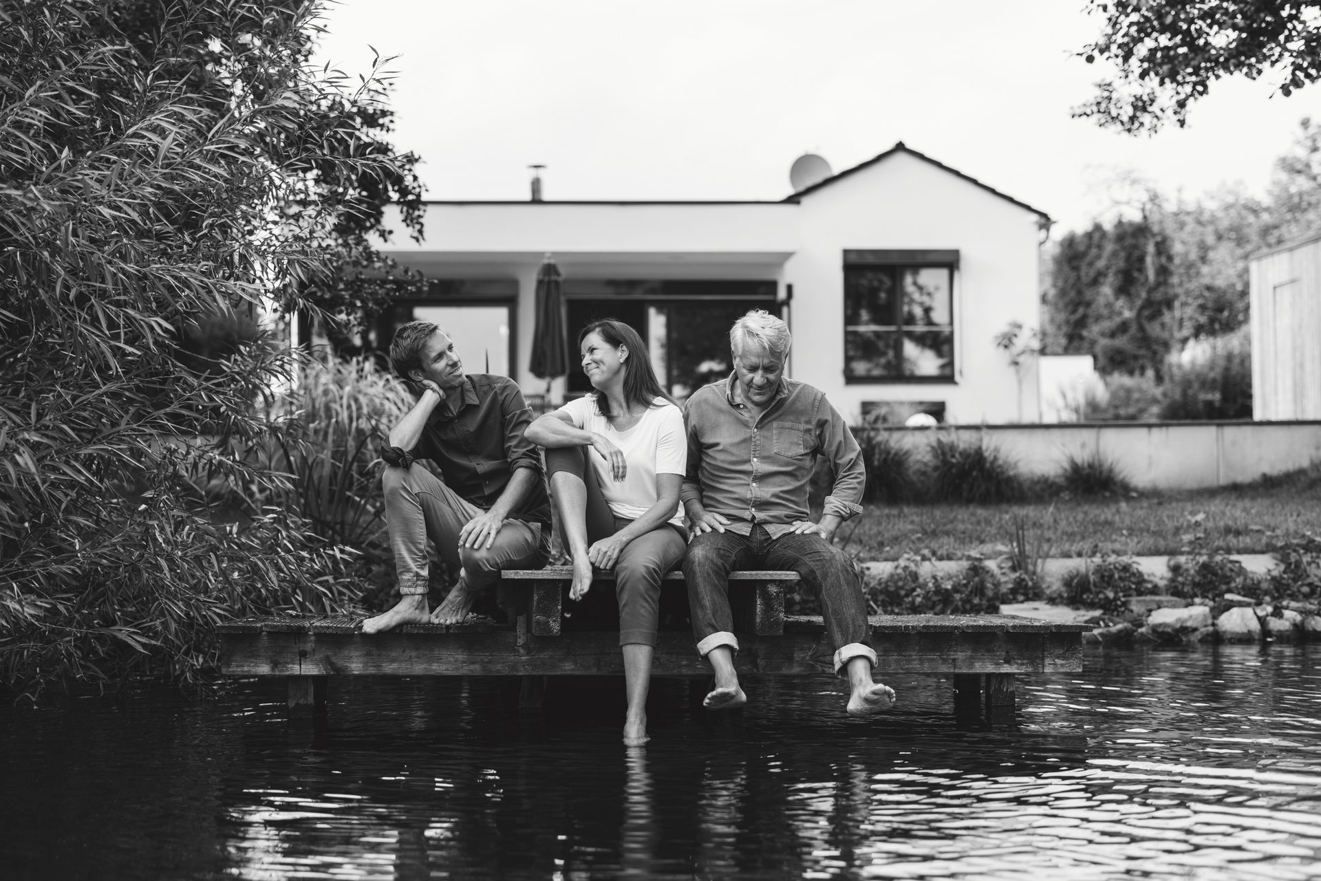 A family sits on the dock of their cottage.