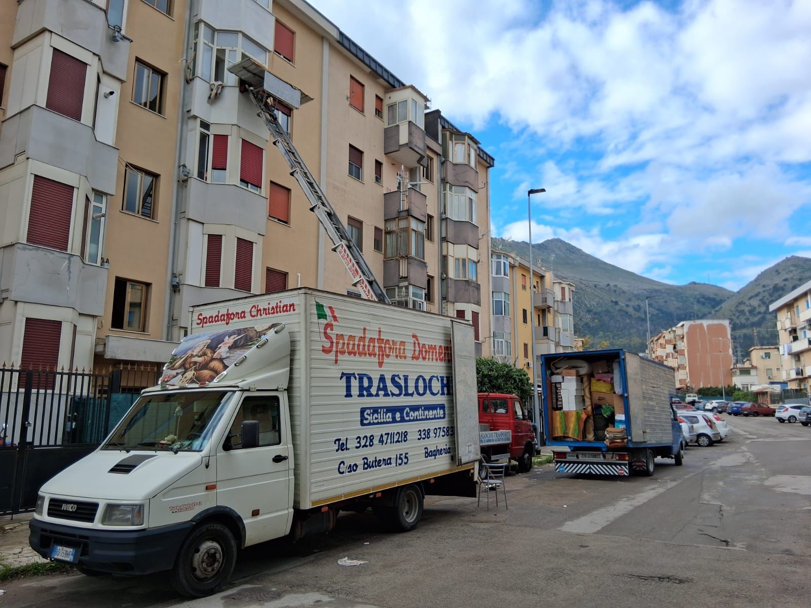 Camion parcheggiato in un magazzino accanto a scaffali pieni di scatole.