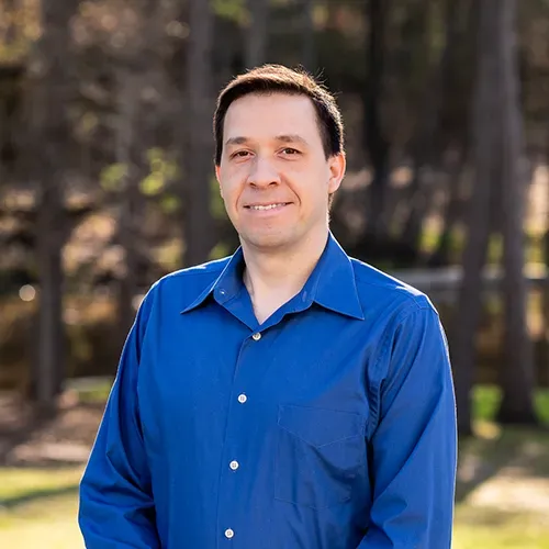 A person wearing a blue button-down shirt