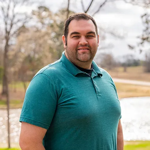 A person with short dark hair and a goatee