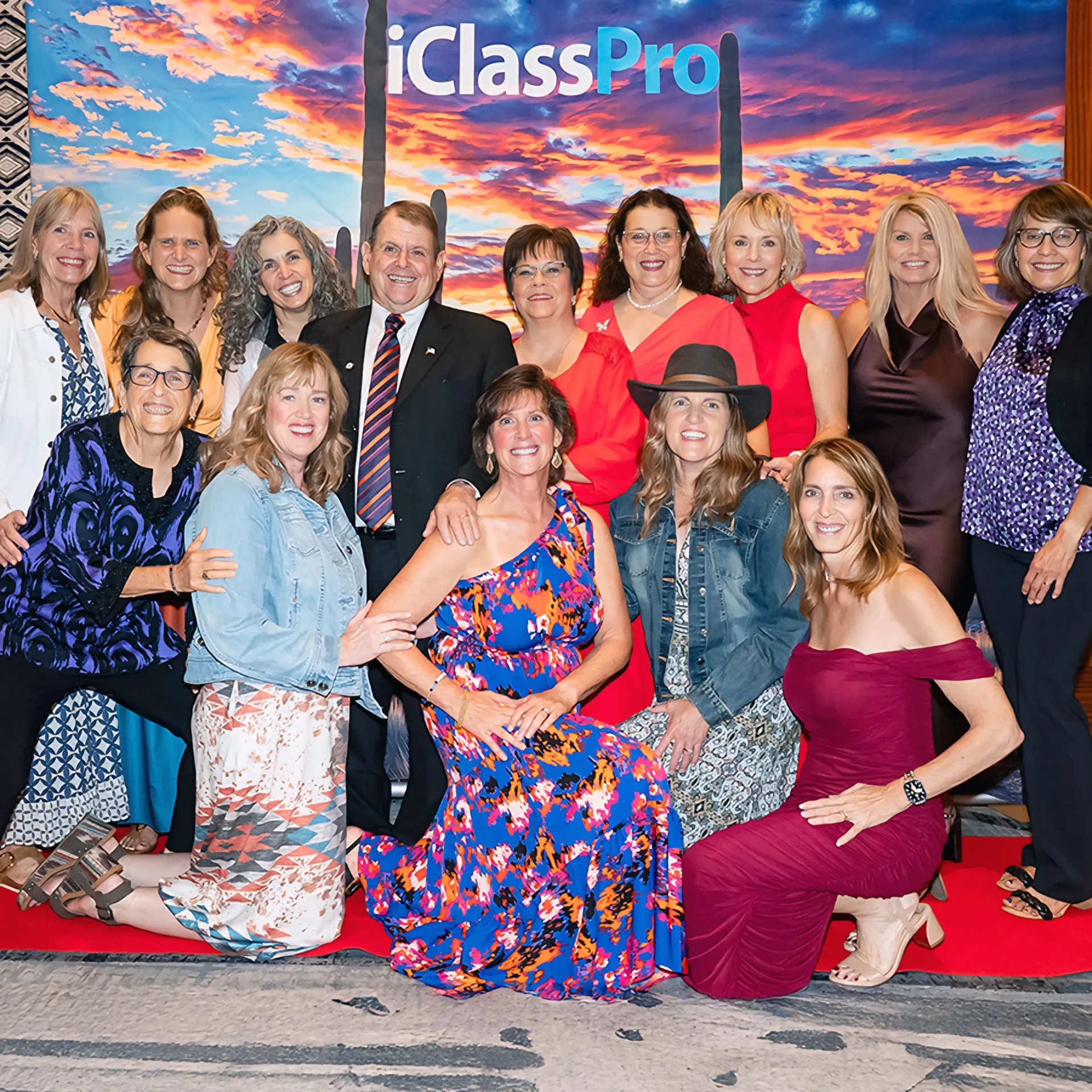 A large group poses in front of an iClassPro backdrop