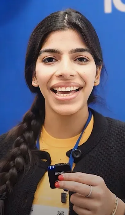 A man with a beard is wearing a lanyard around his neck.