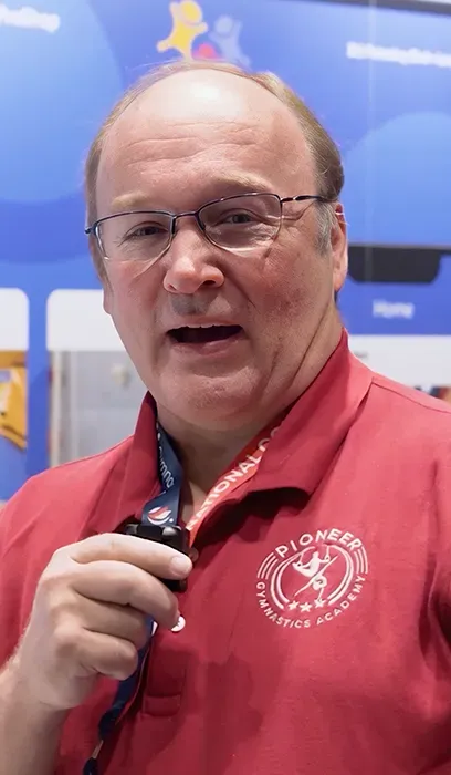 A man with a beard is wearing a lanyard around his neck.