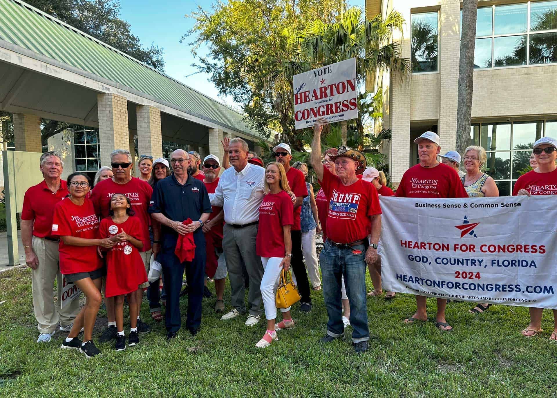 Joe Babits endorsing John Hearton standing in front of a building