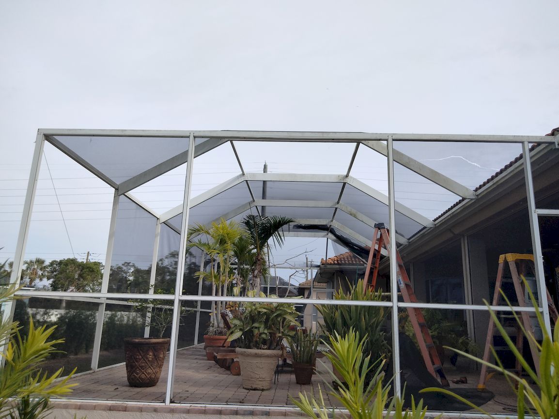 A greenhouse with a lot of potted plants inside of it.