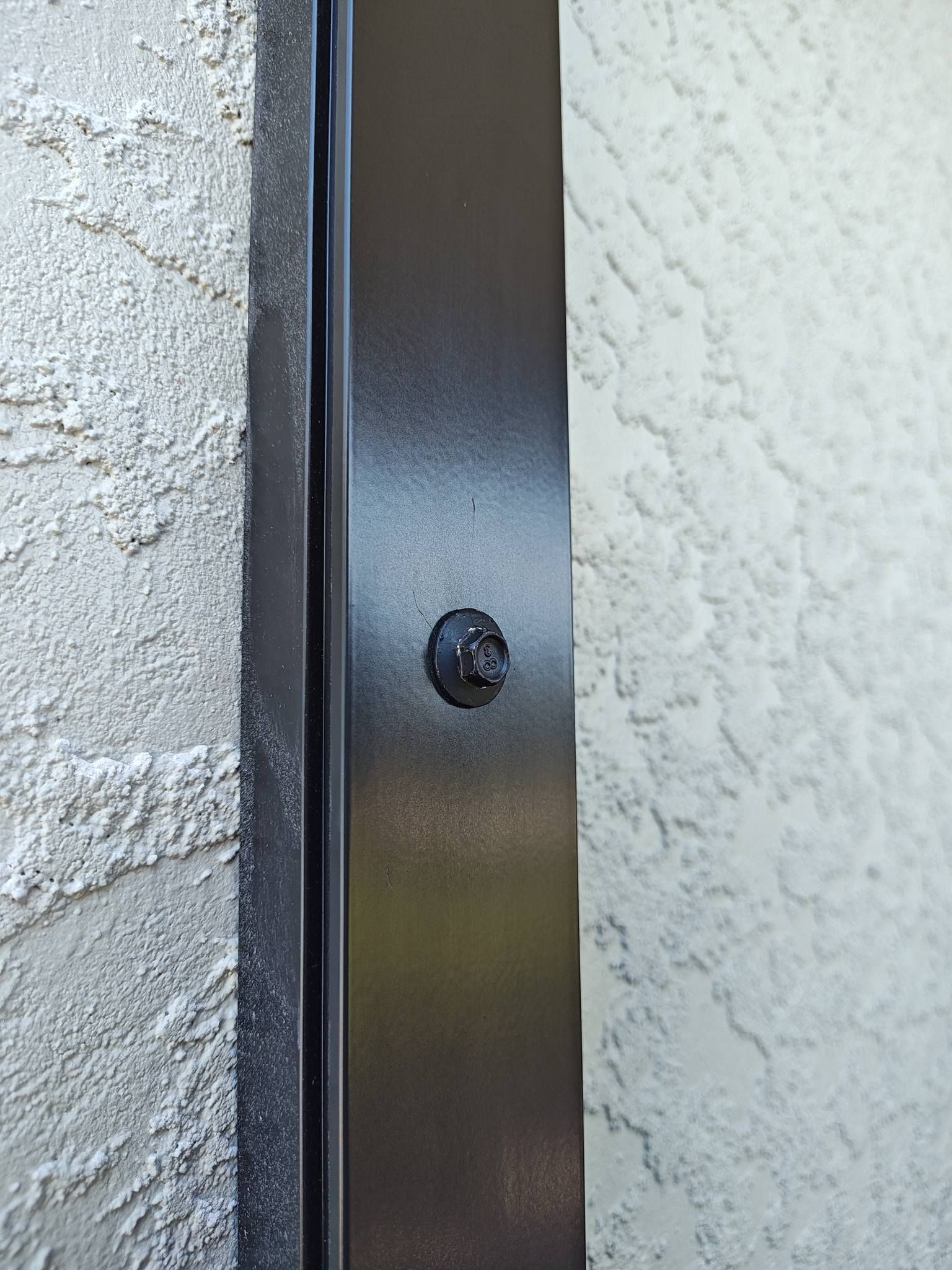 A close up of a screw on a wall.