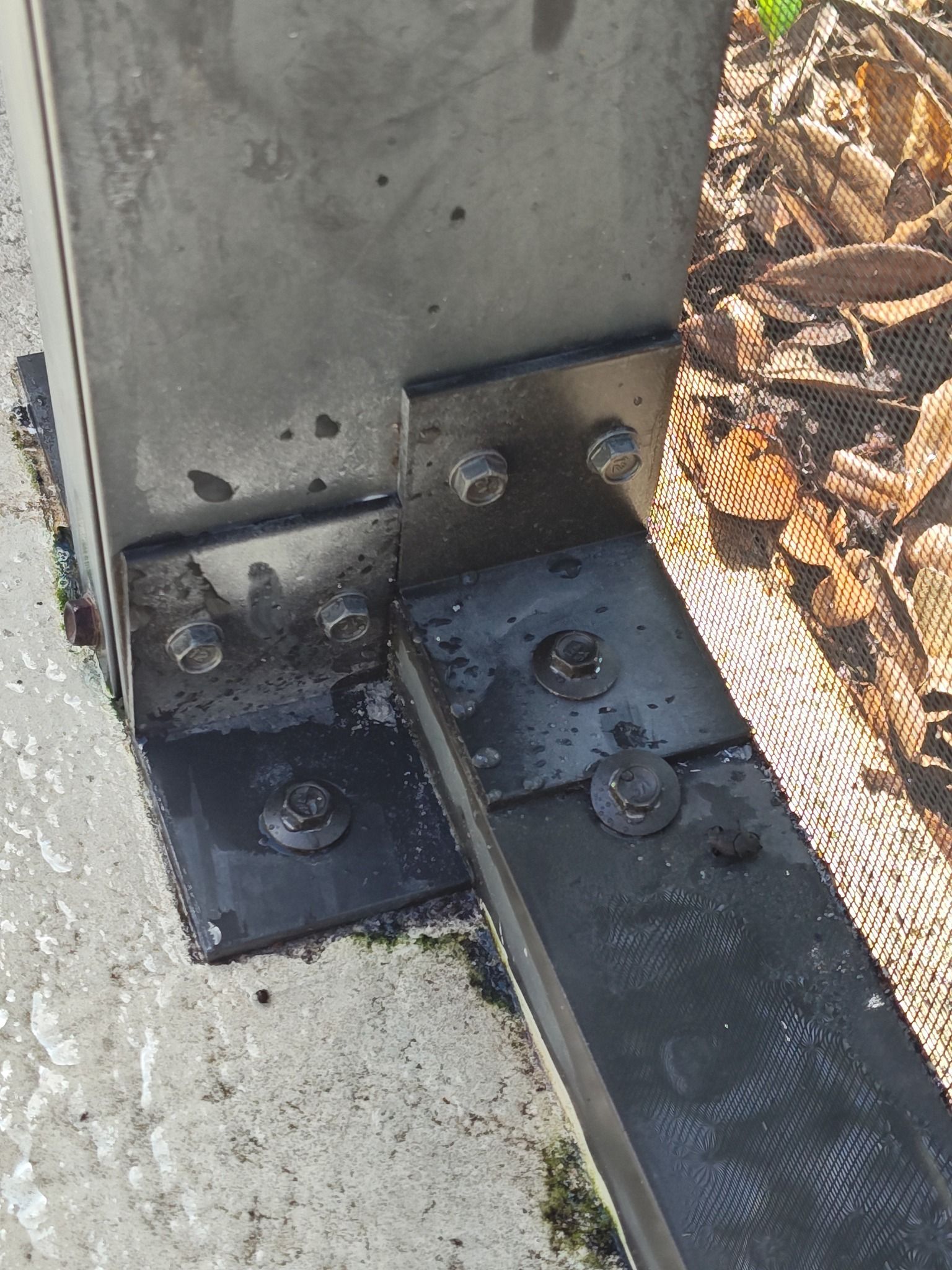 A close up of a metal post with nuts and bolts on it.