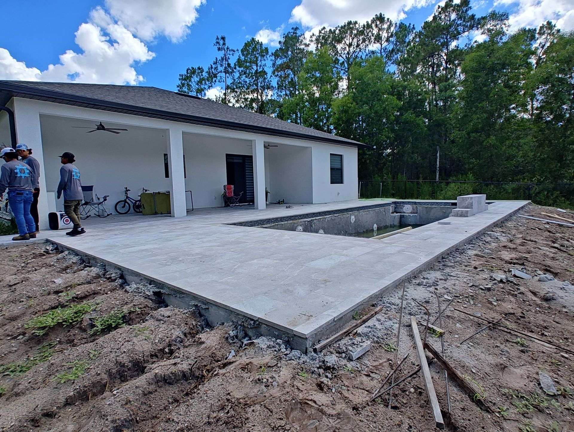 A group of people are standing in front of a house under construction.
