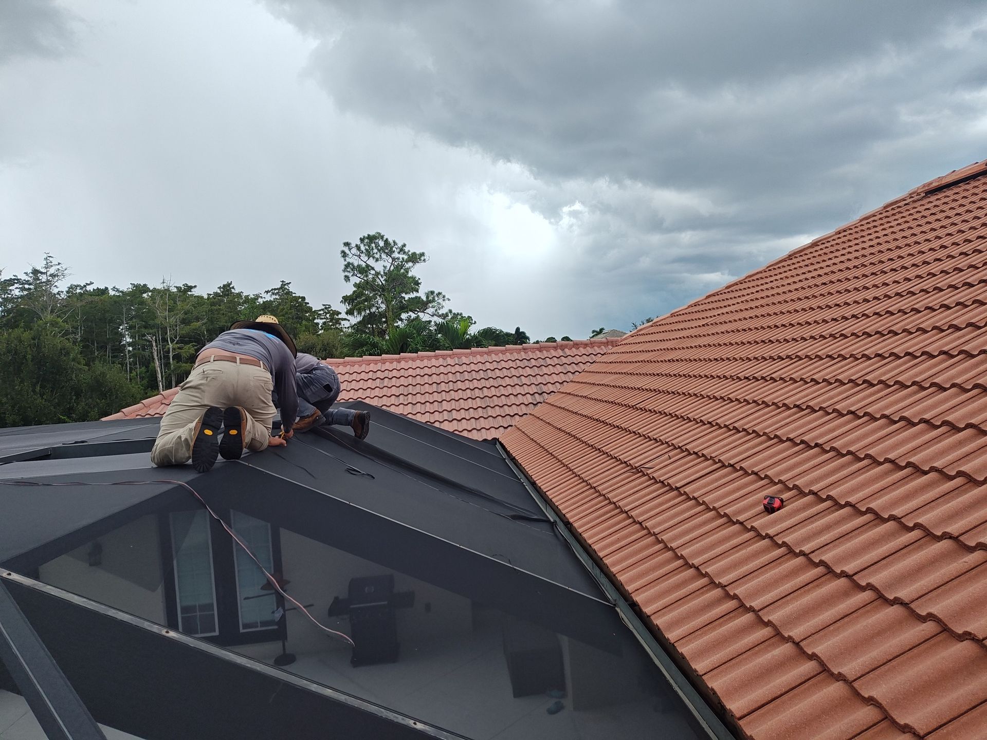 Two men are working on the roof of a house.
