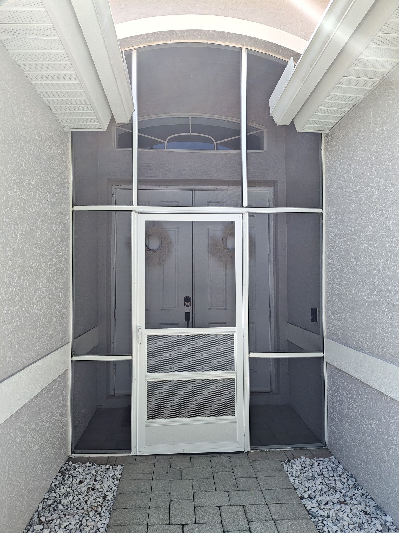 A screened in entrance to a house with a white door