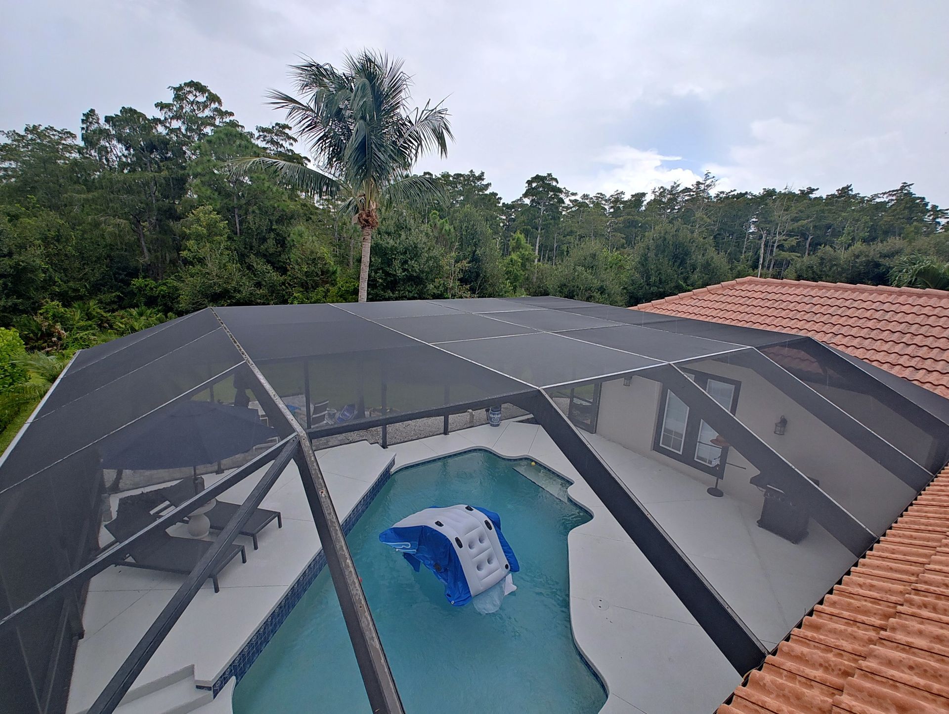 An aerial view of a screened in swimming pool