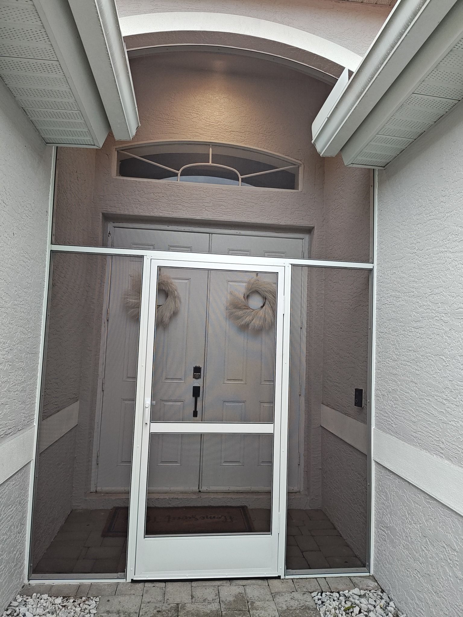 The front door of a house with a screen door