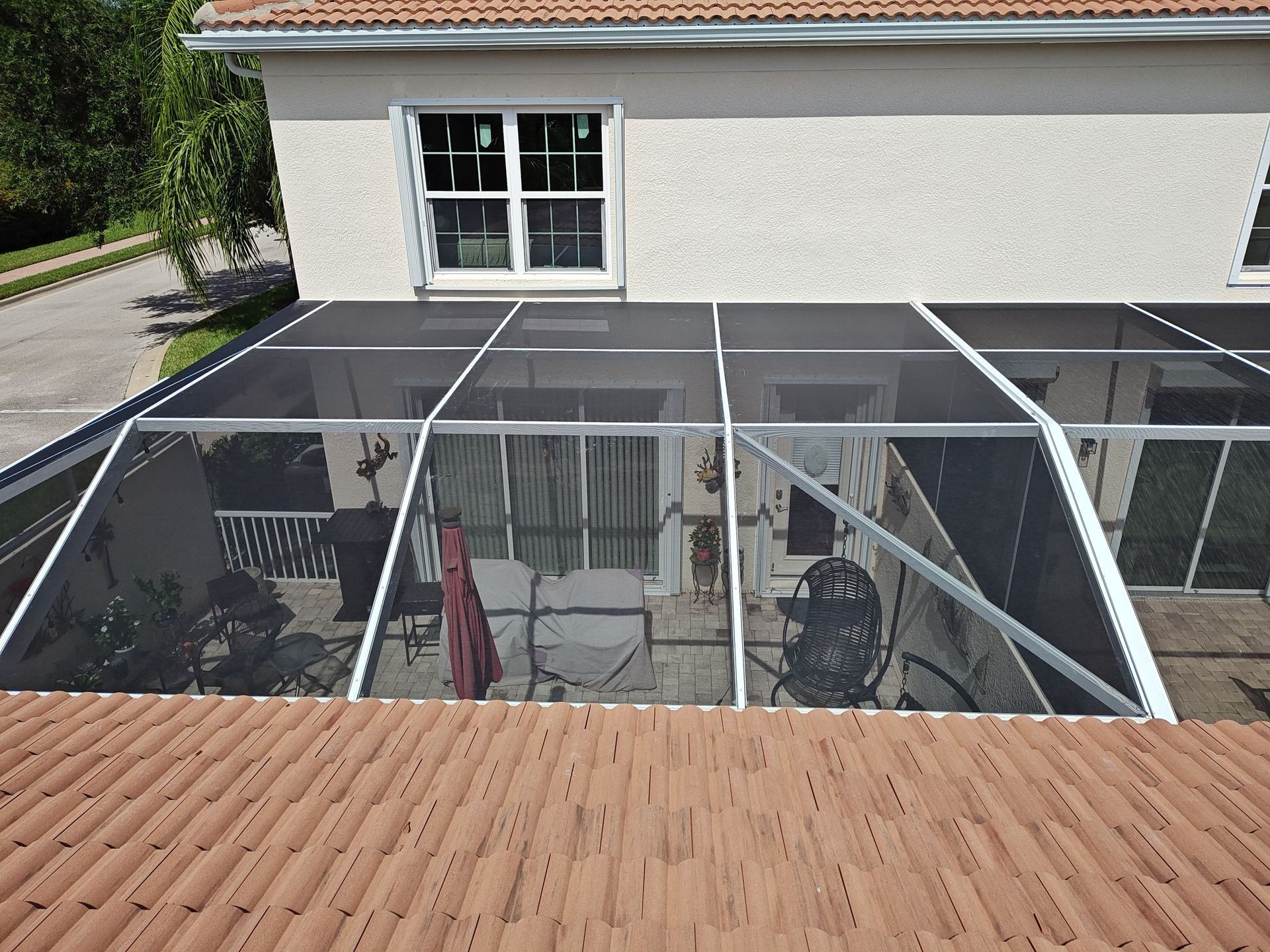 A house with a screened in porch and patio area