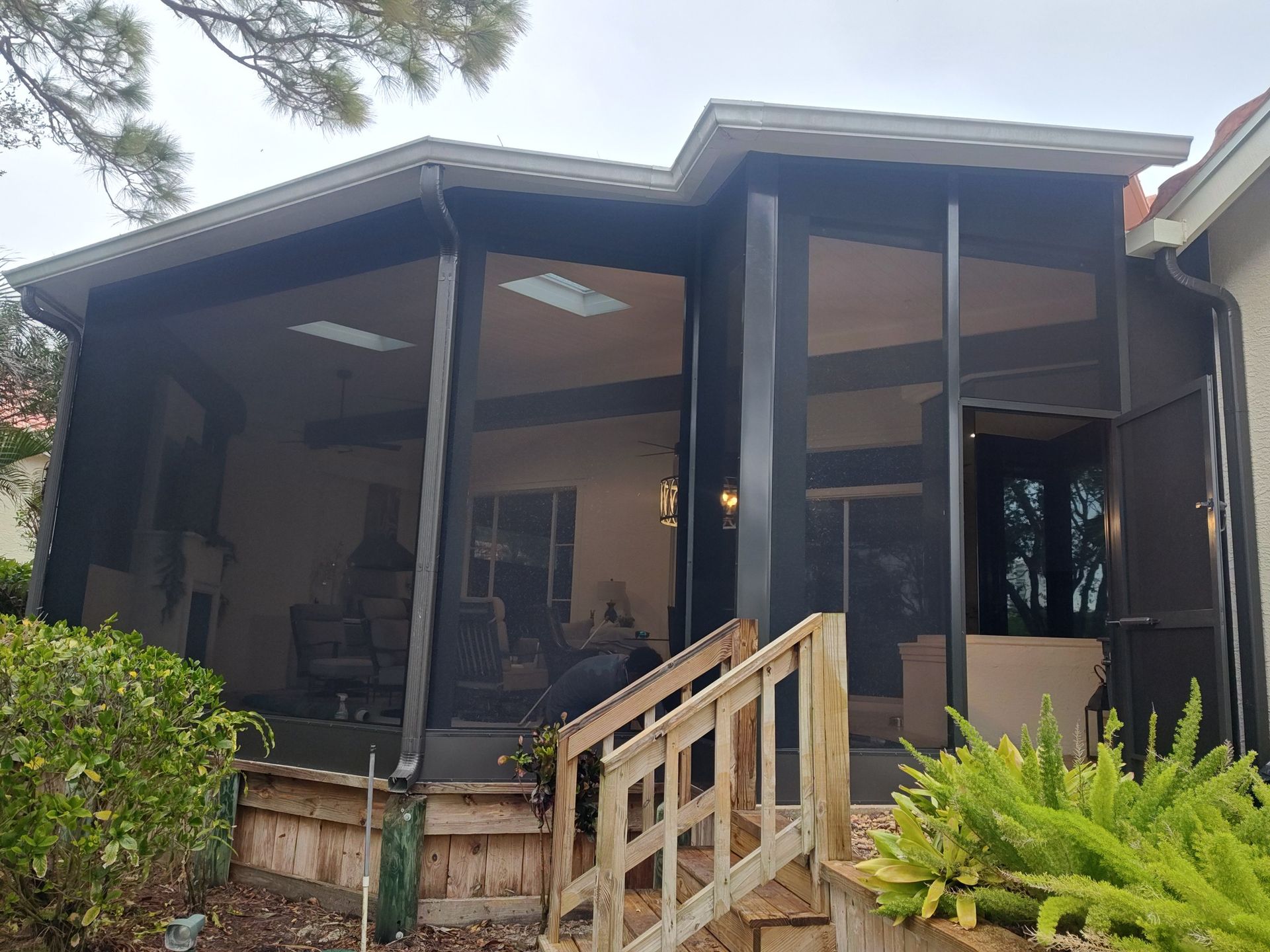 A house with a screened in porch and stairs leading to it.