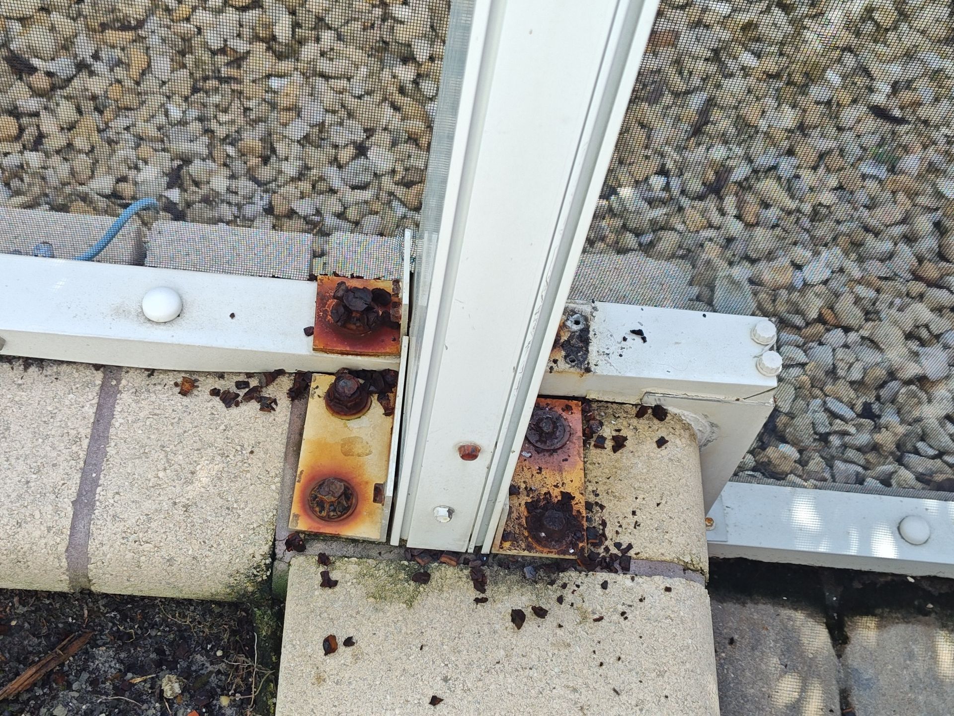 A rusty piece of metal is sitting on a brick sidewalk.
