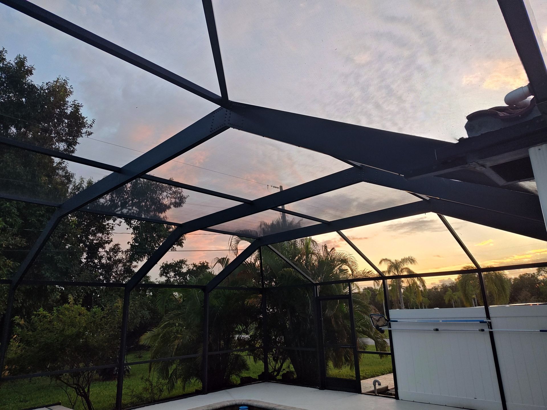 A screened in area with a sunset in the background
