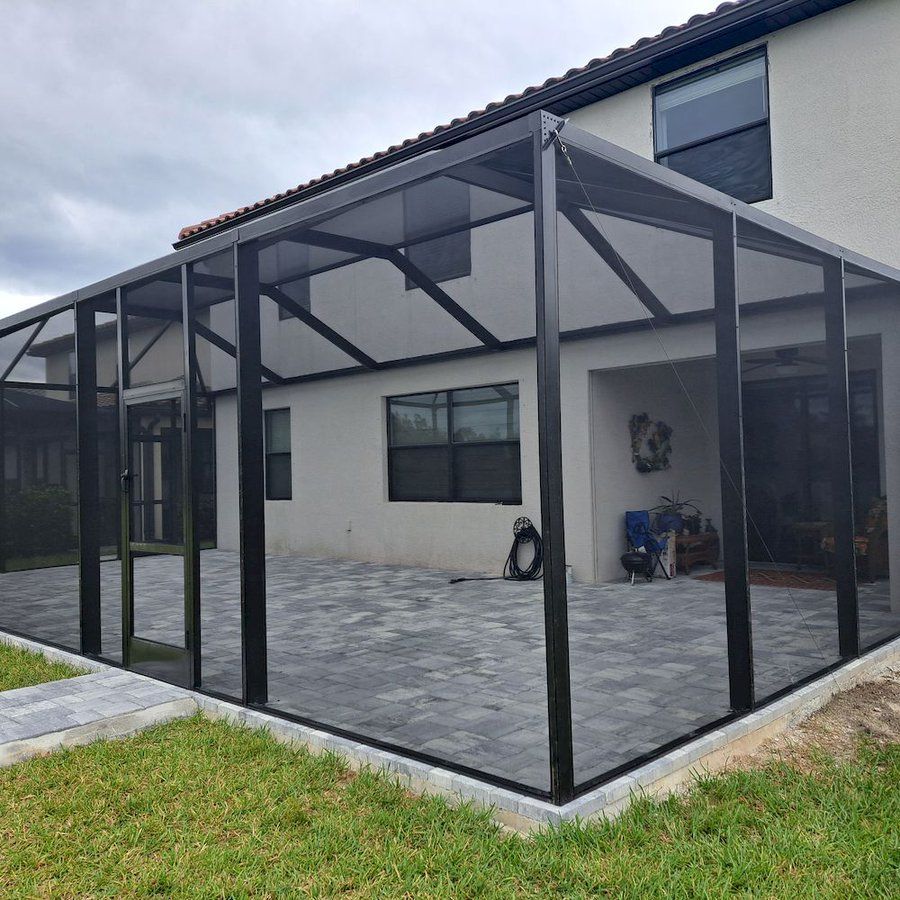 A house with a screened in porch in front of it.