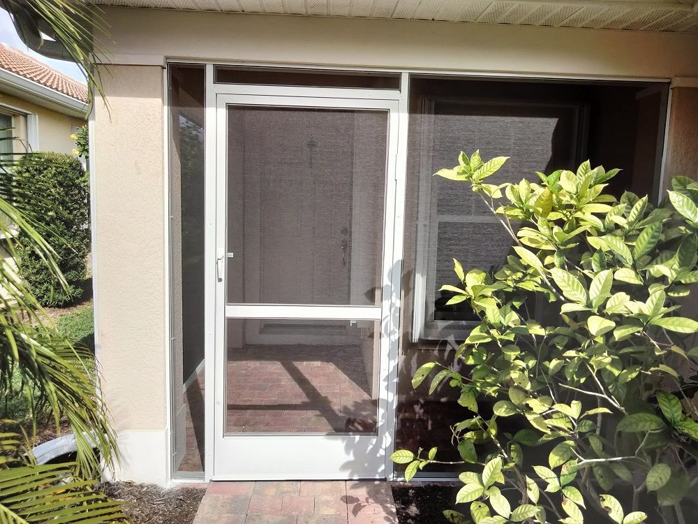 A screened in porch with a white door and a window