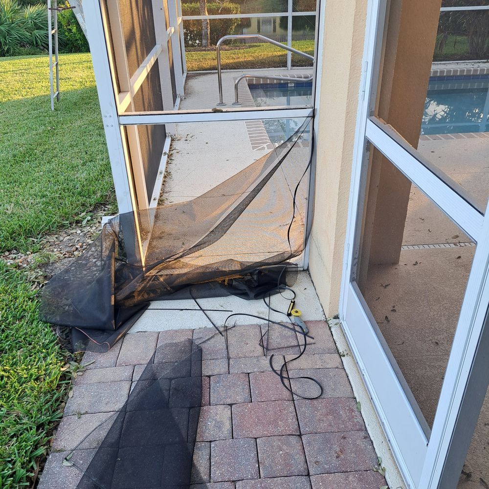 A screened in porch with a broken screen and a pool in the background