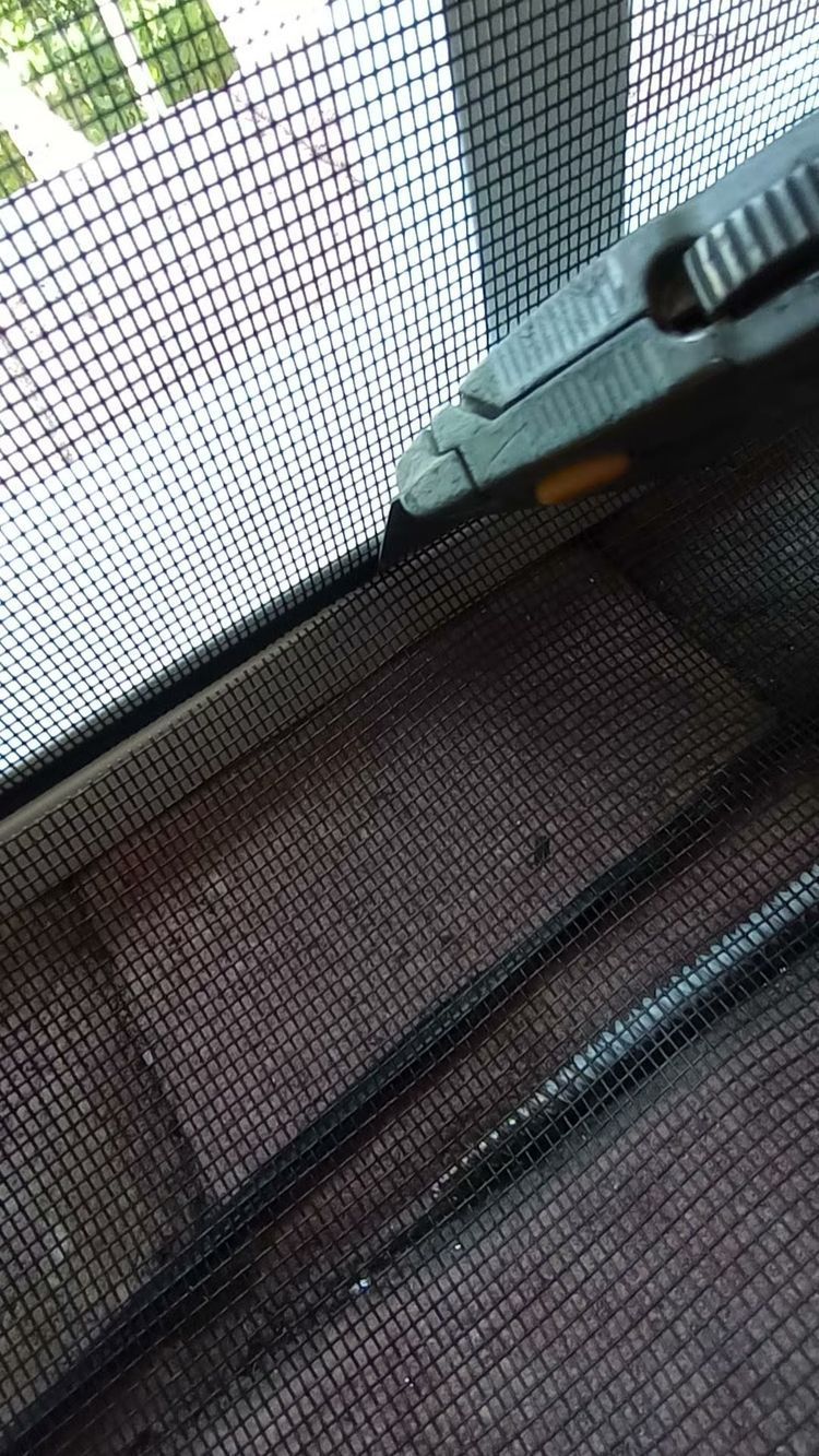 A close up of a mosquito screen on a window.