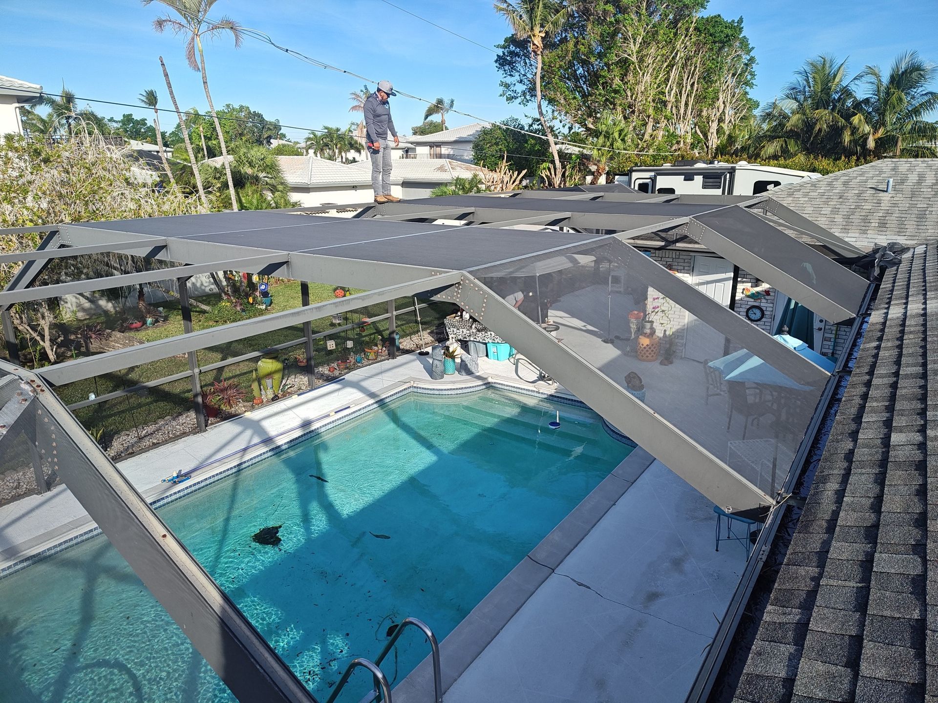 A screened in area with a swimming pool behind it