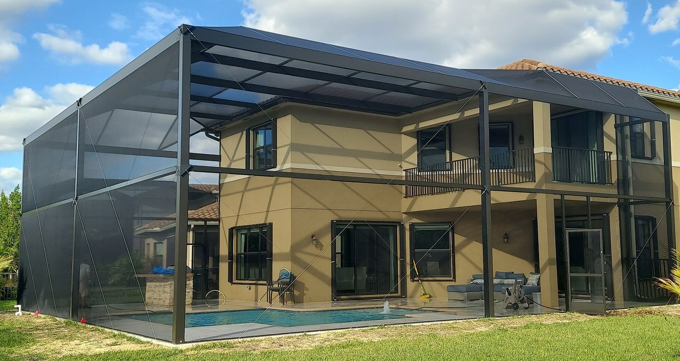 A large house with a screened in porch and a swimming pool.