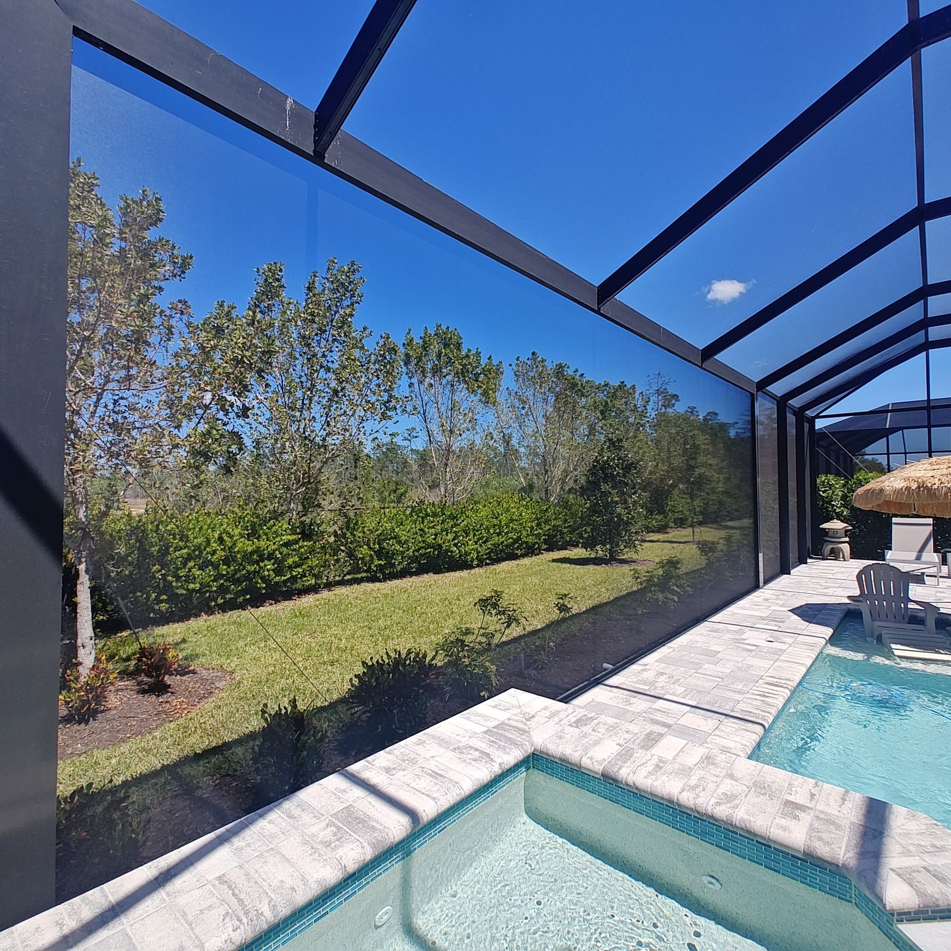 A view of a swimming pool from a screened in area