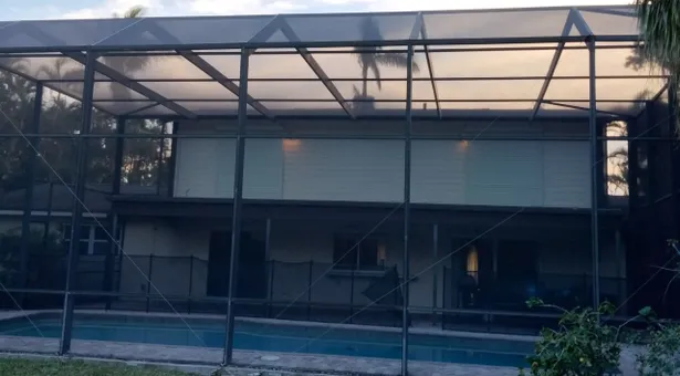 A house with a swimming pool behind a screen.