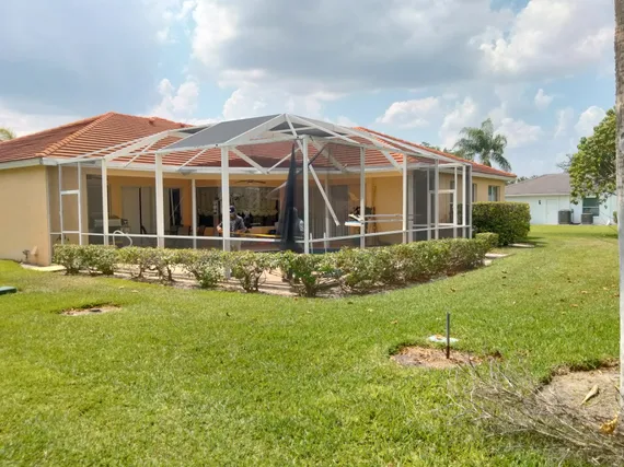 A screened in porch is being built in the backyard of a house.
