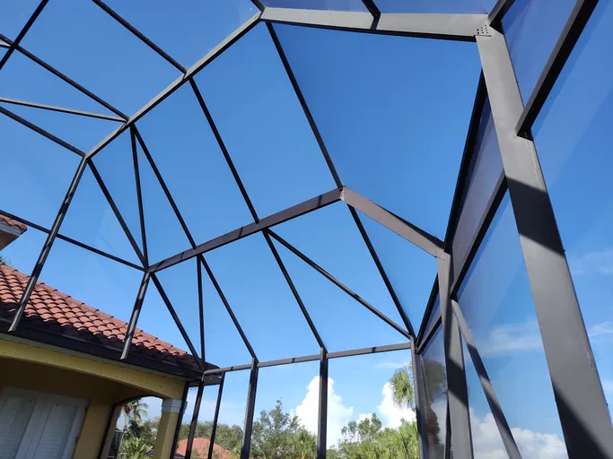 Looking up at the roof of a building with a blue sky in the background