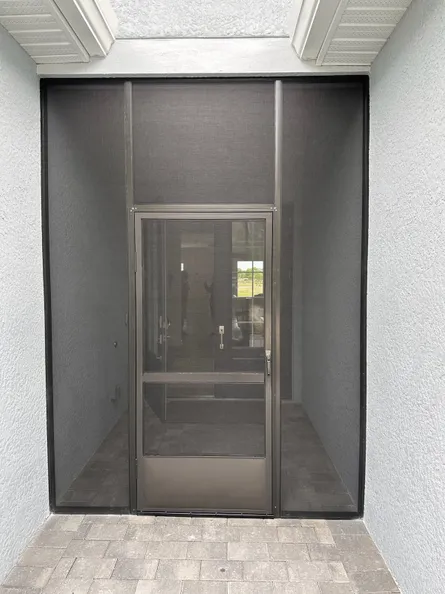 A screened in door with a window in the background