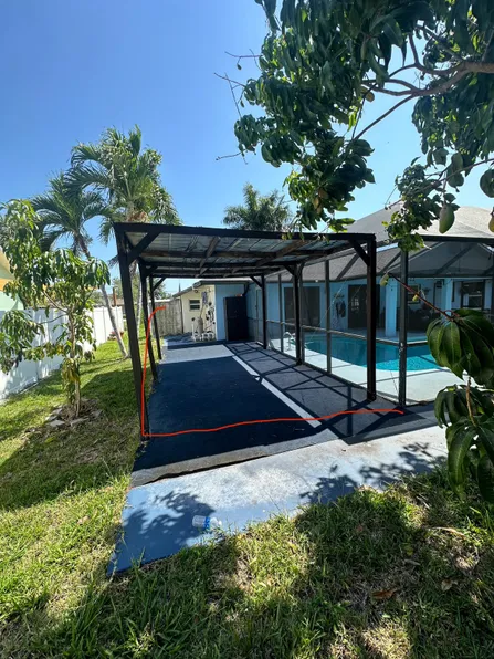 A house with a screened in porch and a swimming pool in the backyard.