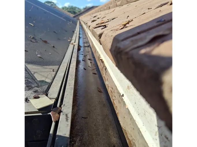 A close up of a gutter on the side of a roof.