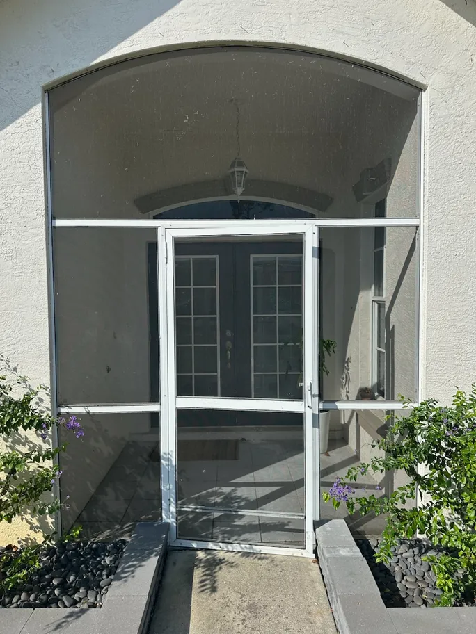 A house with a screened in porch and a door.