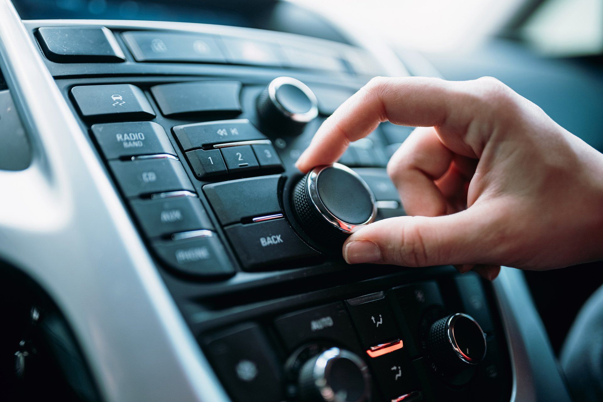 A Person Increasing The Volume Of Car Stereo — Sebring, FL — Bassett Custom Audio Video