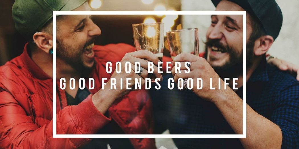 Two men are toasting with beer glasses in a bar.