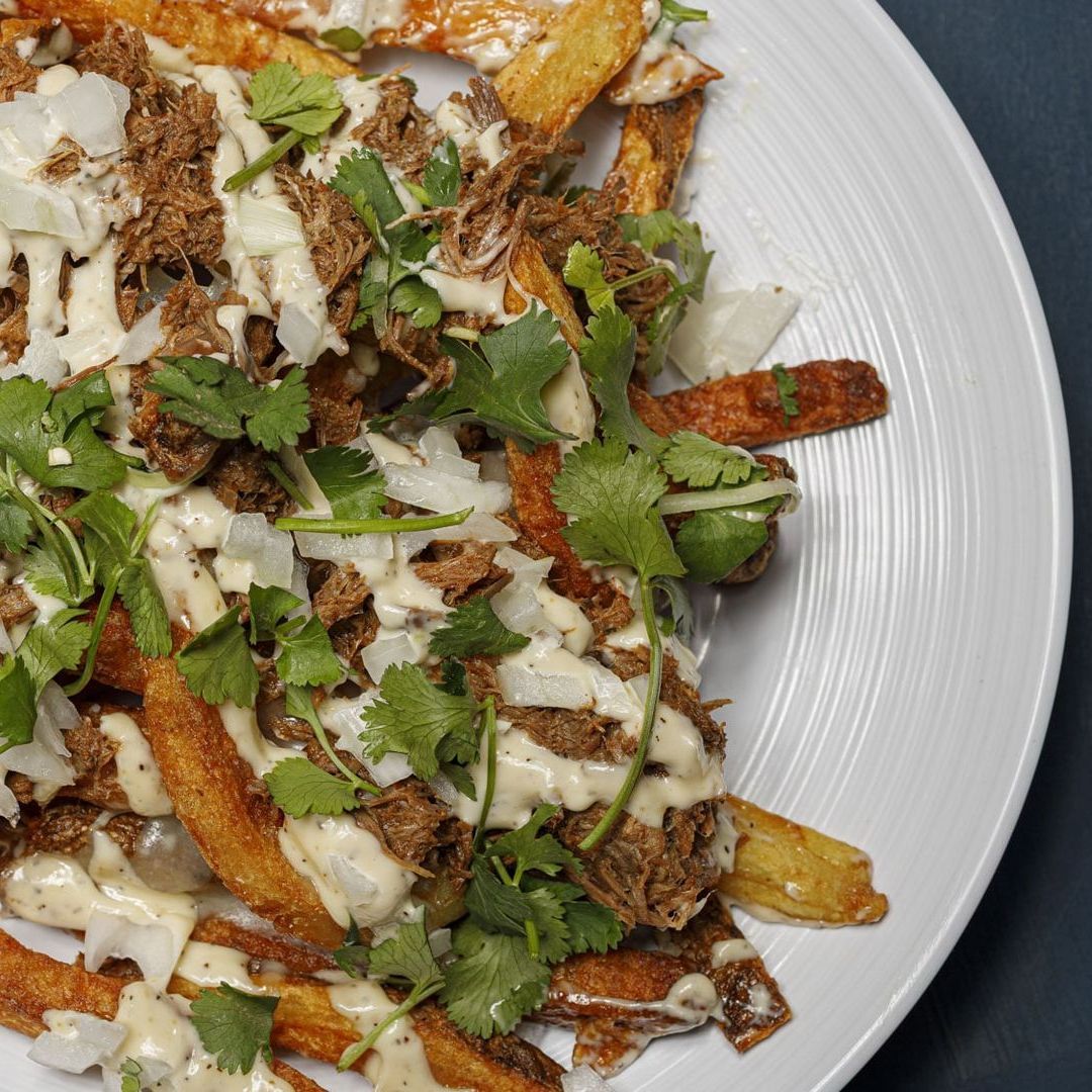 A white plate topped with french fries and sauce
