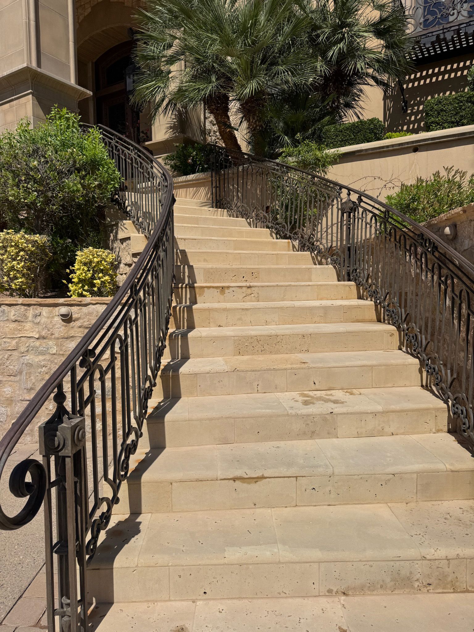 A set of stairs leading up to a building with a wrought iron railing.