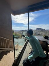 Window washer on a building, squeegeeing soapy glass.