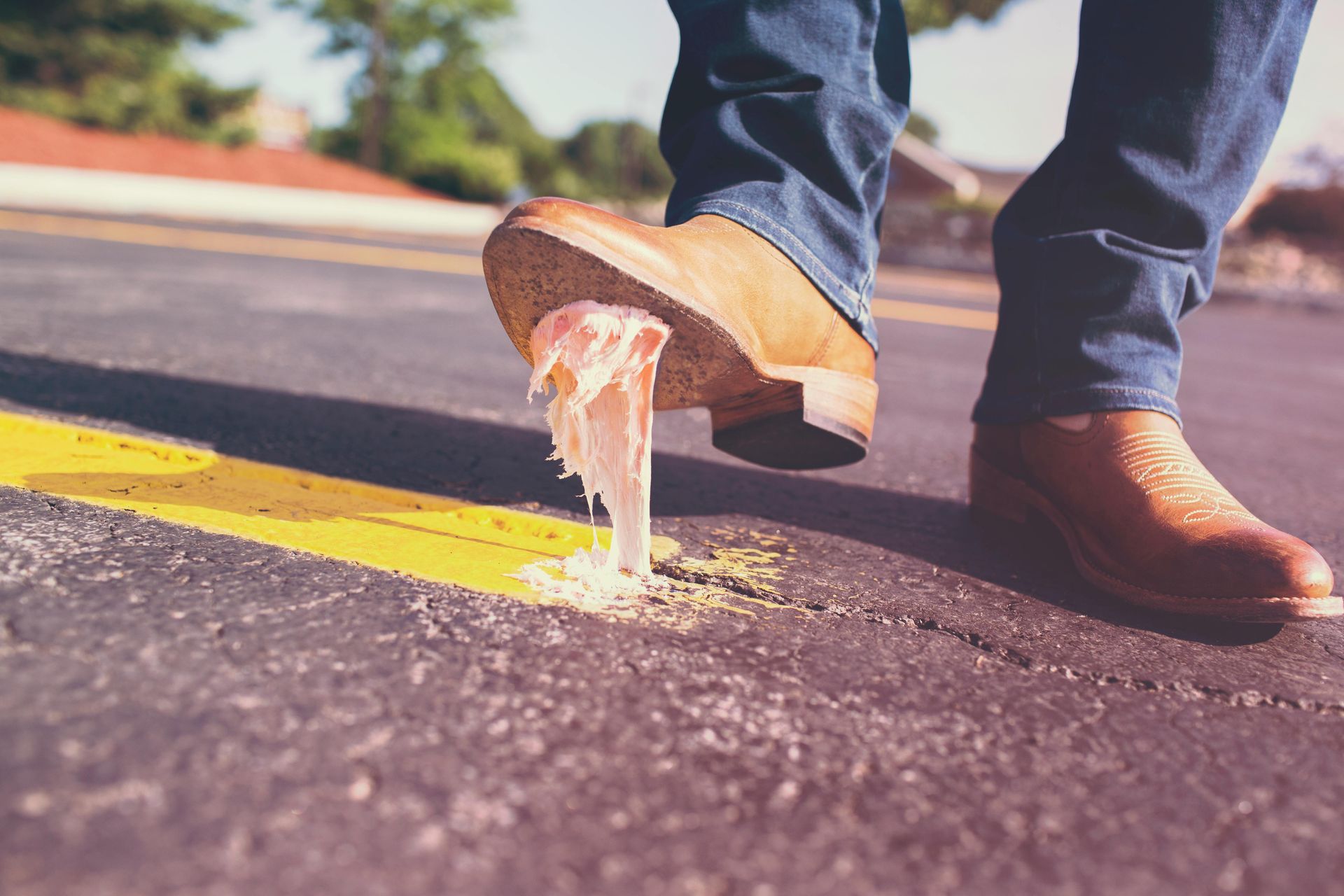 Man stepping on a peeled banana on a road, slipping near a yellow line