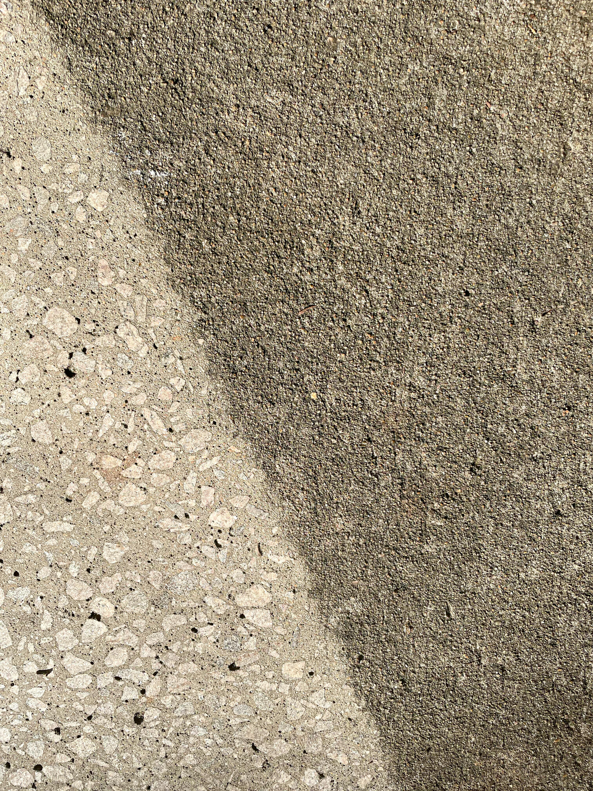 Close-up of a speckled beige and brown textured surface with a diagonal light-to-dark division