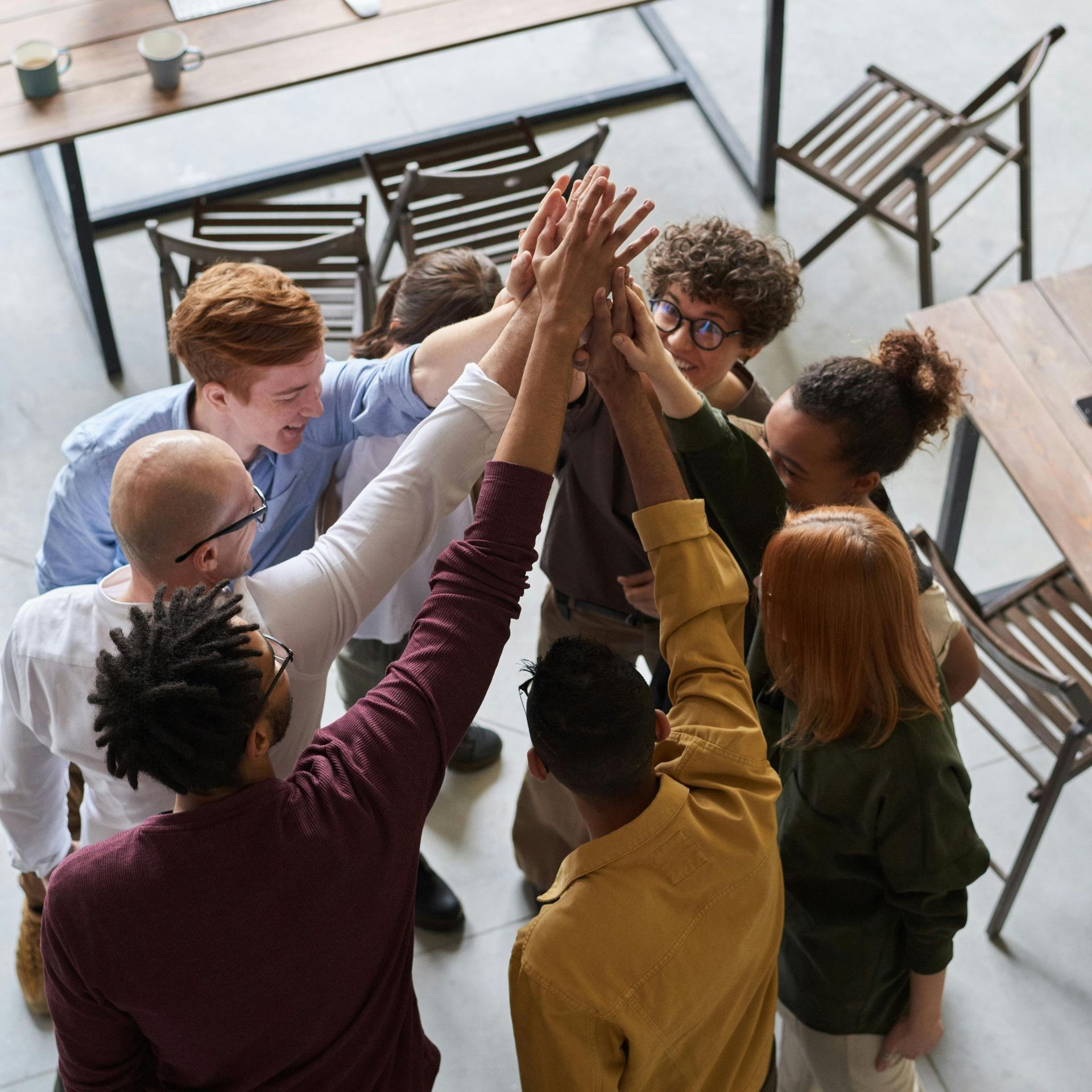 A group of people are putting their hands together in a circle.