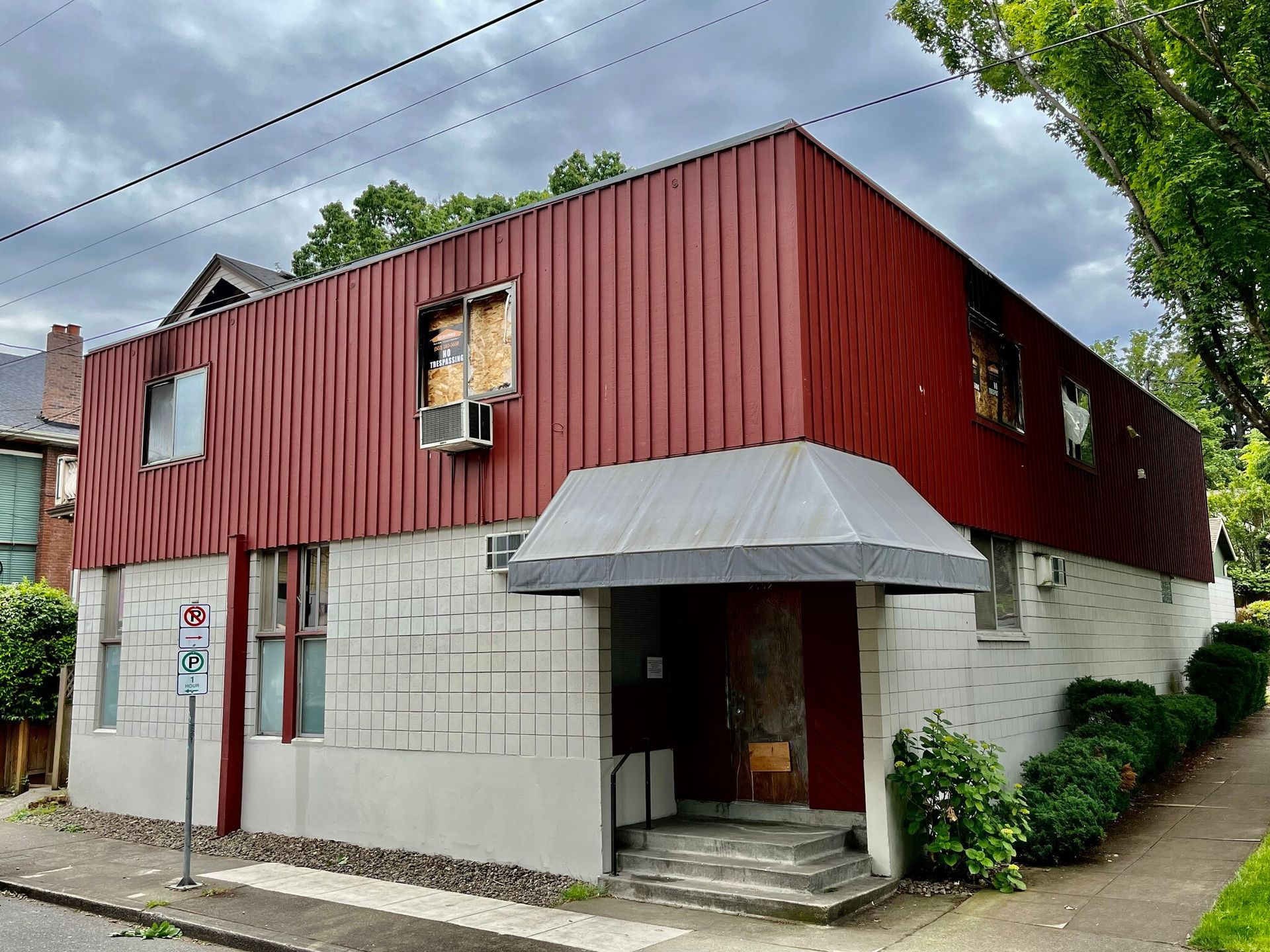 A red and white building with a no parking sign in front of it