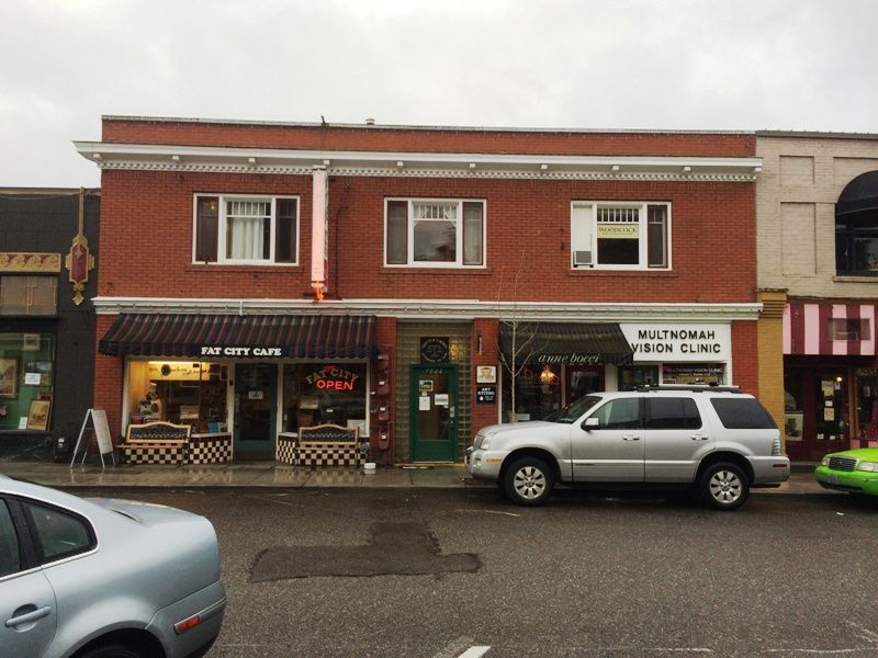 A white suv is parked in front of a brick building