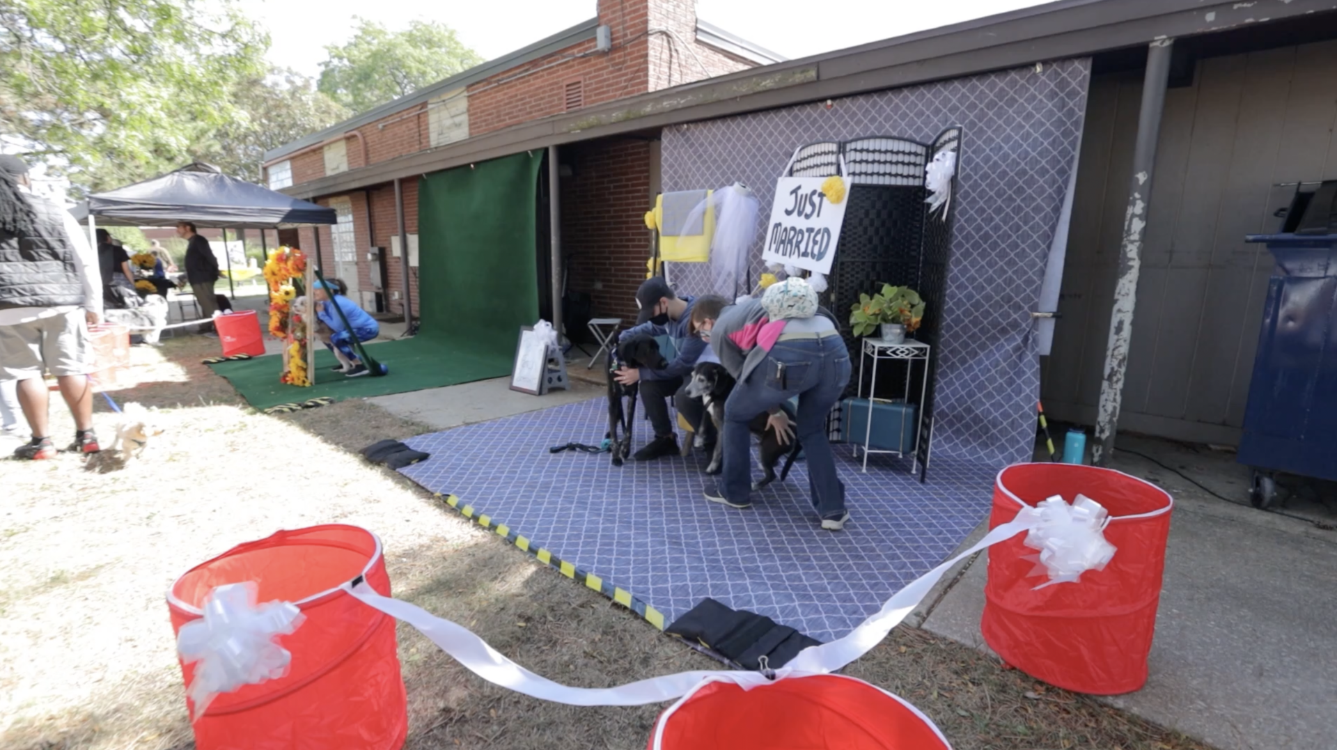 A group of people are playing a game with red buckets filled with cotton candy.