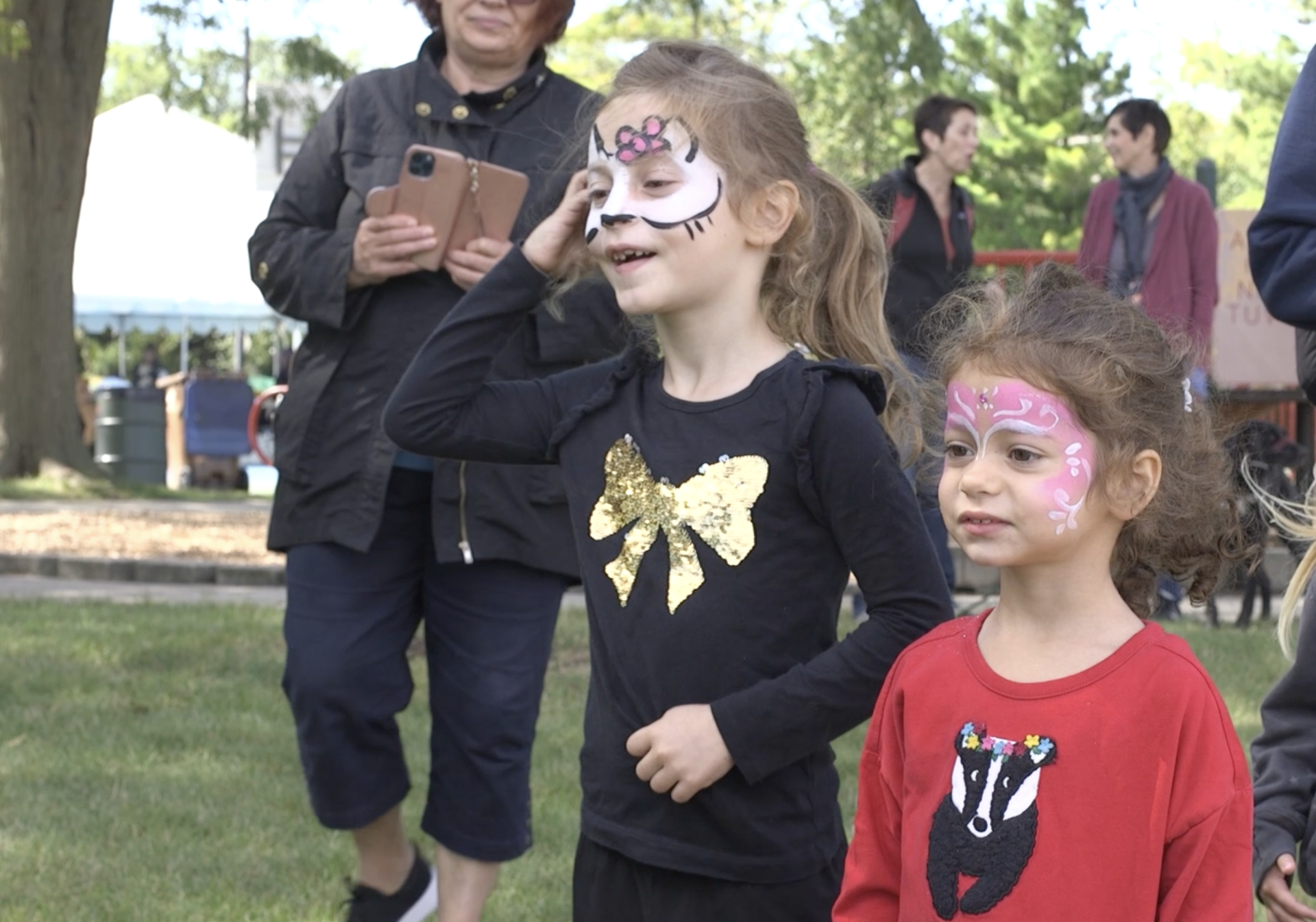 Two little girls with face paint are standing next to each other